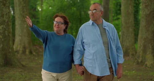Elderly Couple on a Walk in a Forest Park Grayhaired Man and Woman Walking in a City Park Romantic