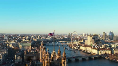 Waving Union Jack Flag Over Palace of Westminster Showcasing Big Ben River Thames London Eye and