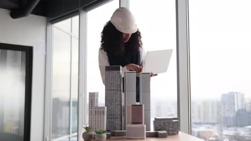 Architect Examining Building Models in Office
