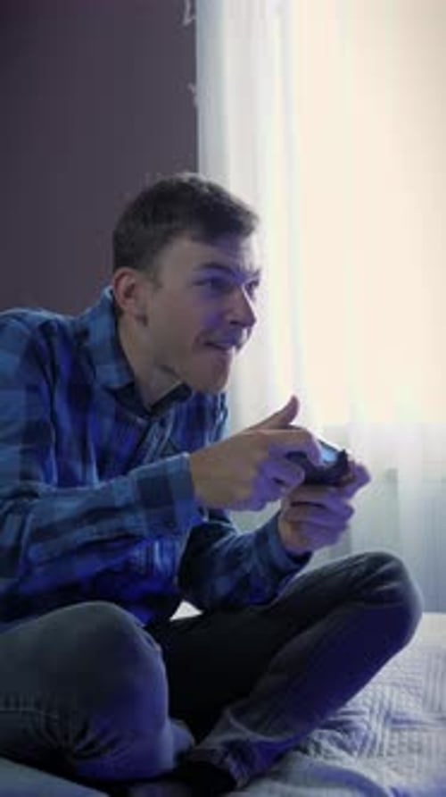 Mann hält den Joystick der Videospielkonsole in der Hand und spielt Online-Spiele. Vertikales Video