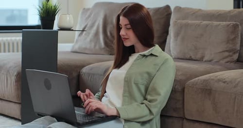 Young Adult Woman Using Laptop in Home Setting