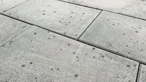 es fängt an zu regnen, Regentropfen fallen auf trockene Pflastersteine, Gartenfliesen
