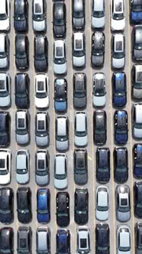An Aerial View of Numerous Parked Cars Neatly Arranged in a Large Parking Lot Area