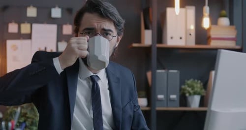 Loop Portrait of Joyful Middle Eastern Employee Drinking Coffee Raising Mug Toasting Looking at