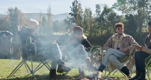 Friends Roasting Marshmallows at Campfire on Sunny Day