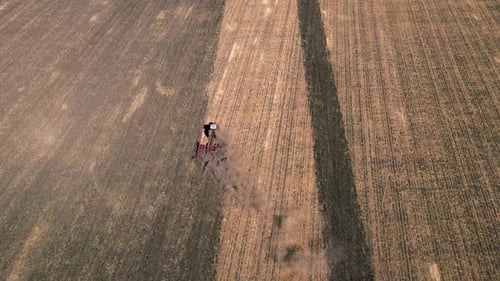 Tractor Working on Field Using Plowing Equipment