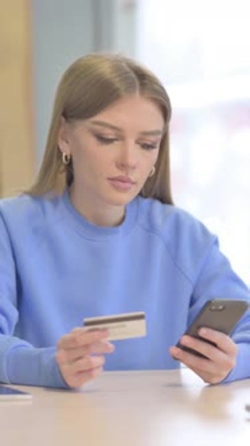 Woman Makes Purchase on Mobile Phone with Credit Card