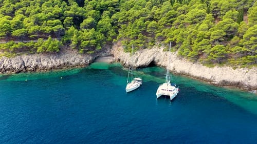 Yacht anchoring in crystal clear turquoise water in front of the tropical island, alternative lifest