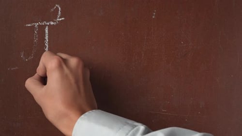 Textured Brown Chalkboard Background Male Hand Writing a Formula Equation on the Board with a Piece