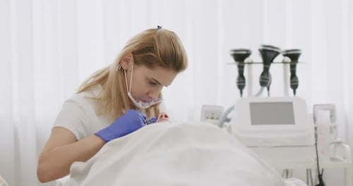 Female Cosmetician Working with Client in Clinic