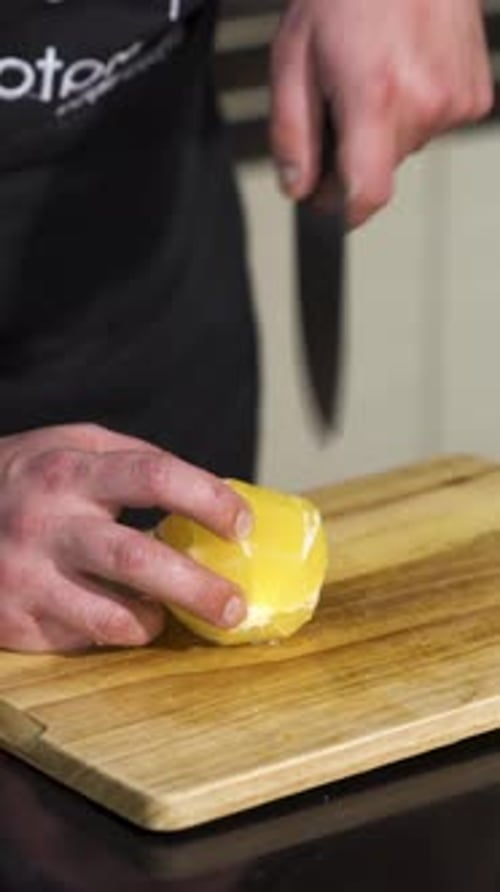 Close Up of a Male Chef Cutting a Fresh Peeled Orange on a Wooden Board Art Concept of Vegan Food