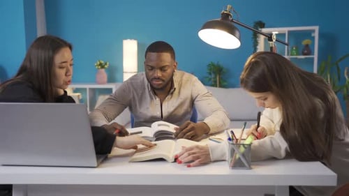 Groupe multiethnique d'amis étudiant à la maison.