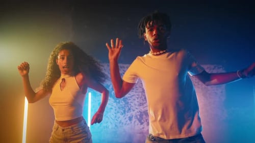 Young Adults Energetically Dancing in Nightclub Setting