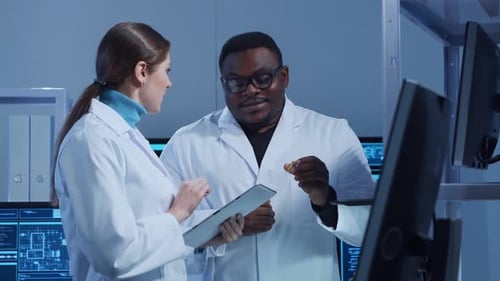 Scientists Discussing Electronic Component in Advanced Lab