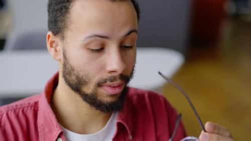 Overtired Young University Graduate Putting Off His Glasses When Finishing Work on Laptop Monitor