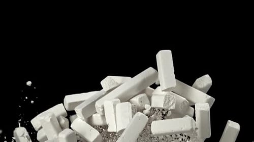 School Chalk Flies Up and Falls Down on a Black Background Filmed on a Highspeed Camera at 1000 Fps