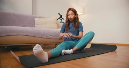 Flexible Hispanic Woman Does Stretching Exercises at Home