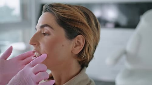 Unknown Cosmetologist Examining Facial Skin Attractive Woman Client In Modern Clinic Close Up. Pr...