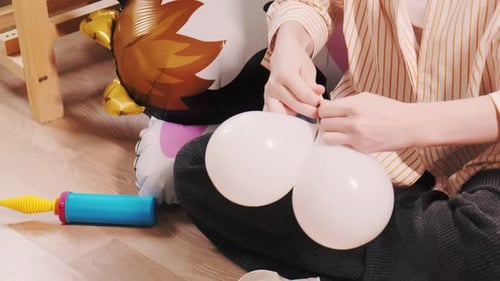 Hands Tying Balloons for a Party Decoration