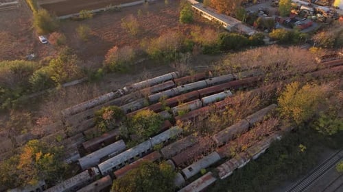 Aerial view of abandoned train graveyard at sunset, Greece.