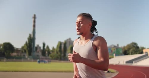 Young African American Runner Athlete Jogging at the Stadium