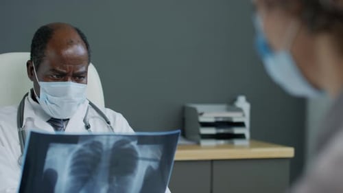 Doctor Studies Chest X-Ray in Office