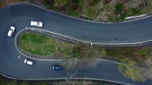 Visão ascendente de cima para baixo de um drone de carros dirigindo e passando por estradas sinuosas ou sinuosas