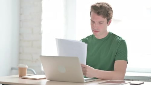 Young Adult Working with Documents at Desk