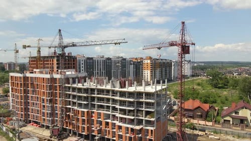 Turmdrehkrane und Facharbeiter in einem im Bau befindlichen Wohnhaus aus Hochbeton