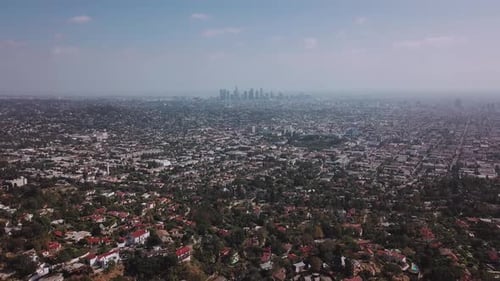 LA: Drone shot over Griffith Park looking out towards the Downtown skyline in the smog with Silverla