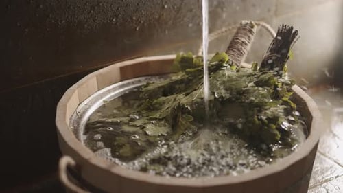 Eichenbesom im Holzeimer im traditionellen Dampfbad Nahaufnahme der alten russischen Banja im modernen SPA