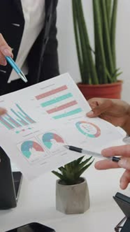 Two Professionals Examine Financial Data in Modern Office