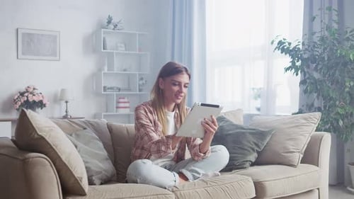 Young Woman Using Tablet Device on Couch