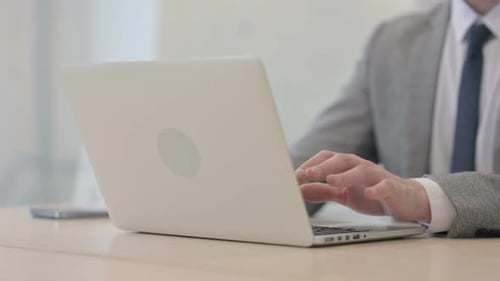 Close up of Young Businessman Typing on Laptop