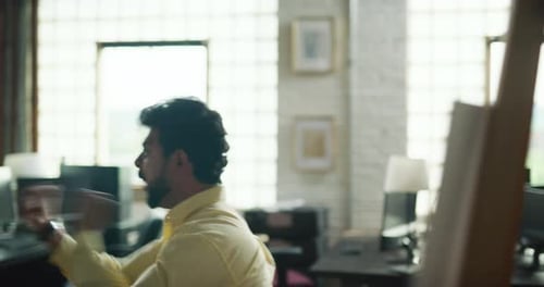 Indian Man Acts Out Sales Pitch Pressentation For Commercial In Modern Well Lit Office During The...