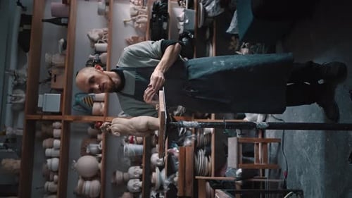 Fulllength Portrait of a Young Bearded Sculptor Molding By Hands a Limestone Figurine in Workshop