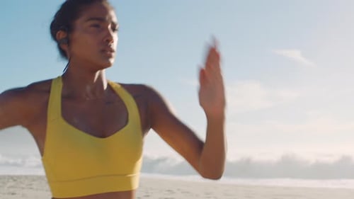 Active, sporty and athletic woman running, training and doing cardio on the beach during summer