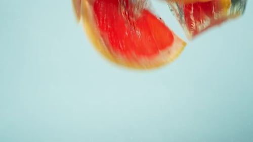 Grapefruit Wedges Splashing Into Water in Slow Motion