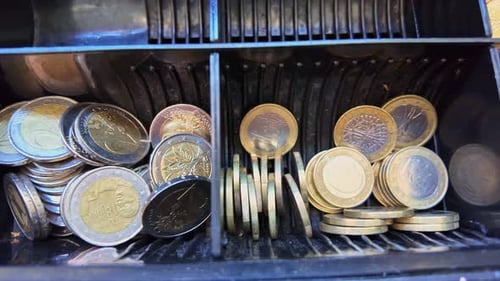 Showing some euro currency coins on panning movement in a cash register, France.
