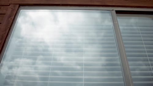 Exterior Window Reflecting Cloudy Sky