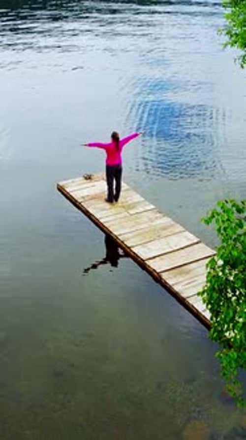 Besinnlicher Moment auf einem ruhigen Dock am ruhigen Wasser an einem ruhigen See