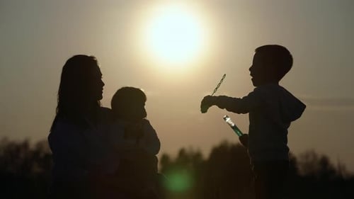 Family Silhouette with Bubbles at Sunset