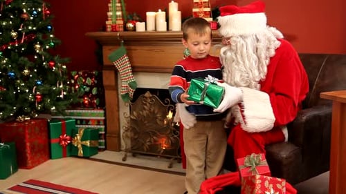 Boy receives gift from Santa at Christmas time