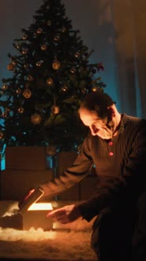 Lonely Sad Man Looks Curiously At Mysterious Gift In His Dark Room