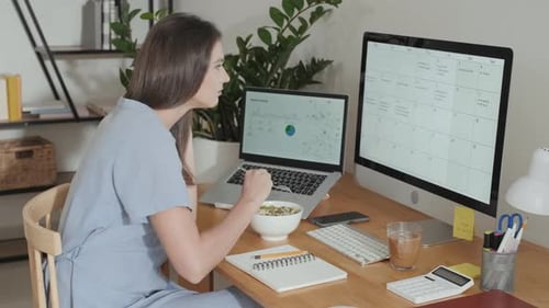 Woman Eating Salad While Working from Home