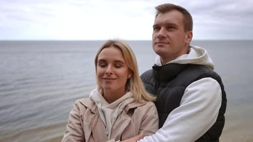 A Lovely Couple Embracing Each Other By the Serene and Calm Sea Enjoying the Moment