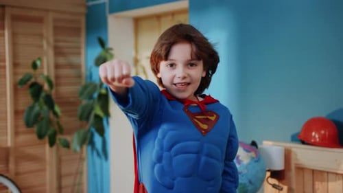Energetic Child Pretends to be Superhero in Costume