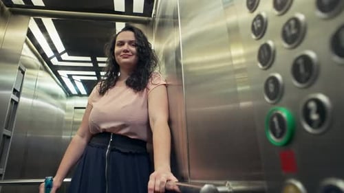 Chica elegante con un vestido en el ascensor con un vaso de champán en la mano