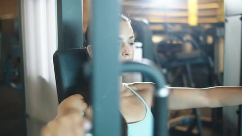 Attractive sporty girl making bicep curls at the gym for a healthy workout