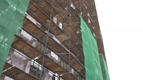 Láminas de plástico sueltas se mueven alrededor de una torre de oficinas esquelética